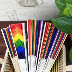 Detail view of colorful rainbow folding fans with white ribs in a basket