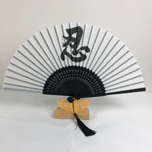 Détail d'un éventail chinois de 6 pouces avec calligraphie '忍' et pompon noir
