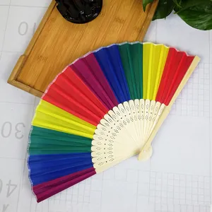 Detail of a rainbow folding fan with colorful fabric and decorative ribs.