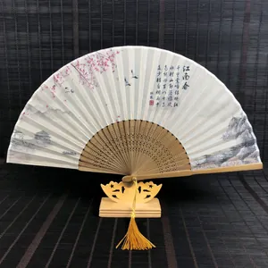 Gros plan d'un éventail chinois de 15 cm en soie avec cadre en bambou et pompon