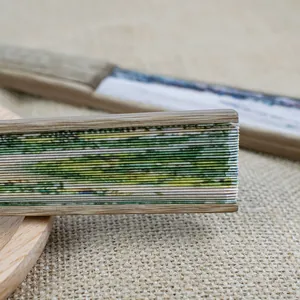 Gros plan détaillé d'un éventail pliant traditionnel en bambou avec motif de paysage