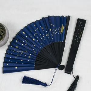 Detailed view of an elegant starry sky folding fan with gold foil stars and blue tassel