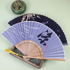 Vue détaillée d'éventails pliants de style Zen avec manches en bambou et motifs d'encre