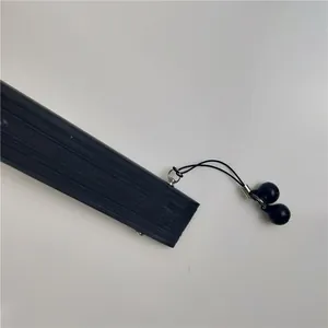 Detailweergave van zwart gelakte waaierhandgreep met een decoratieve hanger met dubbele kralen