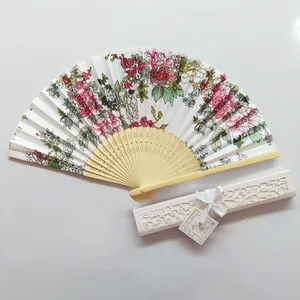 Close-up detail of Japanese folding fan with floral print and elegant hollow-out gift box