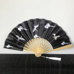 Detailed view of 23cm Chinese folding fan with bamboo ribs and crane satin pattern