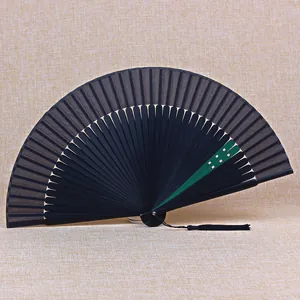 Detailed view of a 21cm traditional black folding fan with green accent and silk tassel.