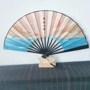 Detailed shot of a traditional Chinese folding fan with mountain sunrise landscape print