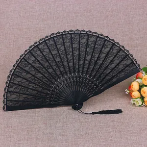 Abanico plegable vintage de encaje negro con motivos florales y borla elegante.