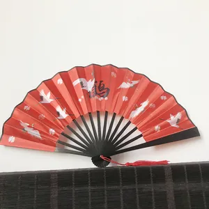Close-up of 23cm red folding fan with crane pattern and bamboo ribs in Chinese style
