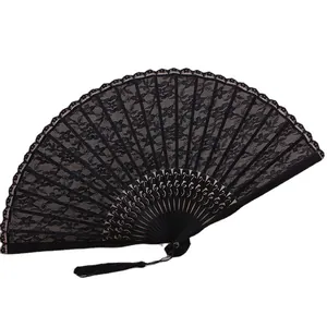Detalle de un elegante abanico plegable de encaje negro con motivos florales retro.