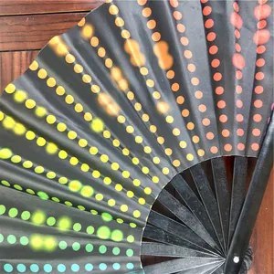 Close-up of large bamboo folding fan with rainbow gradient polka dot pattern.