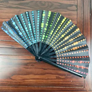Detailed view of 33cm bamboo folding fan with colorful gradient dots on black fabric.