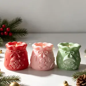 Close-up of festive Christmas gift bag shaped scented candles in three vibrant colors.