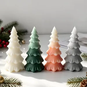 Set of four Christmas tree scented candles in gradient colors on festive background