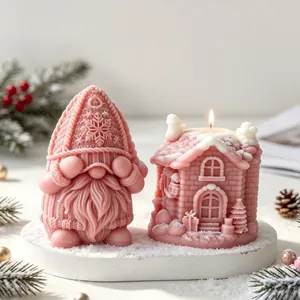 Close-up detail of pink Christmas gnome and cottage candles featuring snow accents