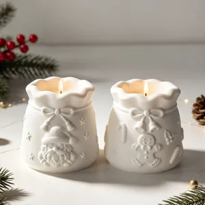 Detail showing two white Christmas lucky bag shaped candles with Santa and gingerbread reliefs.