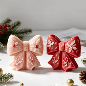 Detail von rosa und roten Weihnachtskerzen in Schleifenform mit festlichen Mustern