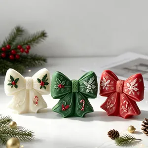 Dekorative Weihnachts-Schleifenkerzen in Weiß, Grün und Rot mit festlichen Mustern.