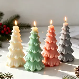 Set of four colorful Christmas tree scented candles lit in a cozy festive setting