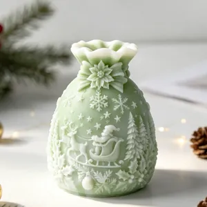 Detailed view of Santa Claus and reindeer relief on a green Christmas gift bag candle.