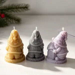 Close-up detail of handcrafted gnome candles in three colors featuring a mushroom house