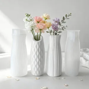 Silicone molds for DIY plaster vases alongside finished white decorative flower holders