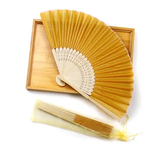 Close-up of golden silk bamboo folding fan with matching organza gift pouch