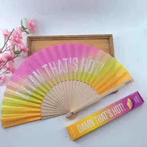 Detalle de abanico plegable con degradado rosa a amarillo y texto 'DAMN THAT'S HOT!'