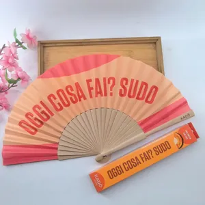 Vista detallada de un abanico español de madera con texto y su caja naranja a juego.