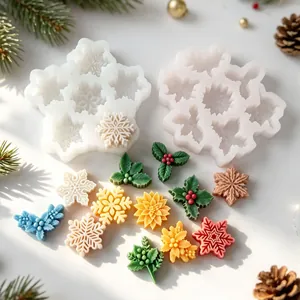 Close-up detail of silicone molds featuring colorful snowflake and holly leaf wax shapes