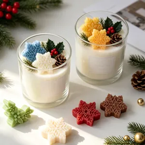 Detailed view of scented candles with Christmas snowflake and holly leaf decorations