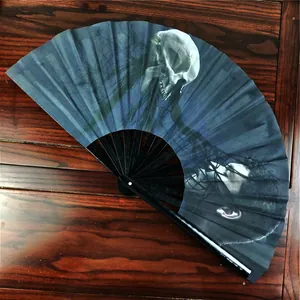Detail of 33cm folding fan with gothic skull and face print on dark blue fabric
