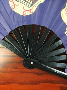 Close-up detail of a folding Kung Fu fan showing black plastic ribs and skull print.