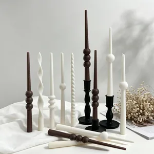 Detailed close-up view of various spiral and geometric taper candles in cream and brown colors