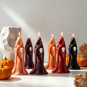 Détail de bougies artisanales en forme de sorcière et de crâne pour Halloween