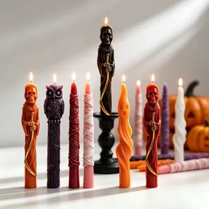 Close-up view of Halloween taper candles with detailed skeleton and ghost carvings