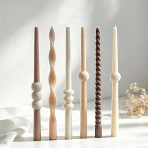 Detailed close-up of decorative taper candles featuring spiral and bubble designs in earth tones.