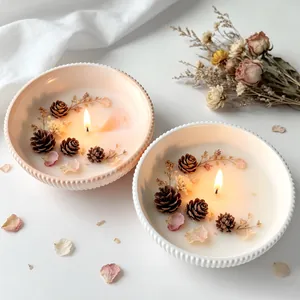 Macro detail of elegant decorative candle bowls with pinecones and dried flowers