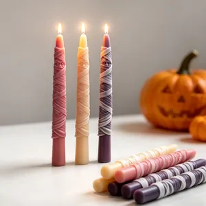 Detailed view of lit Halloween mummy taper candles with unique bandage texture.