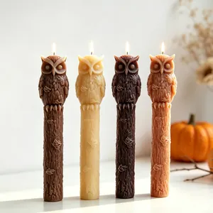 Detailweergave van vier brandende uilkaarsen op houten stammen voor Halloween-decor