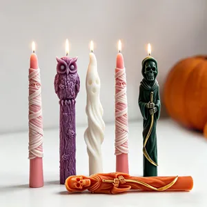 Detailed view of Halloween themed taper candles featuring mummy, ghost, and grim reaper designs.