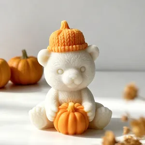 Detailed macro view of a cute white bear candle wearing a knitted orange pumpkin hat