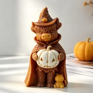 Detaillierte Makroansicht einer Halloween-Hochlandkuh-Kerze mit Hexenhut und Kürbislampe.