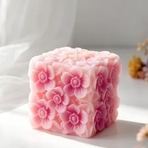 Detailed macro view of a pink square aromatherapy candle with embossed floral patterns
