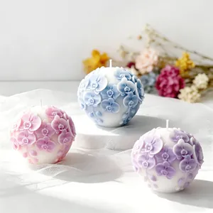 Detail view of three exquisite orchid embossed spherical scented candles in pastel colors
