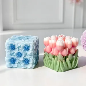 Close-up of intricately carved floral cube candles in blue and pink tulip designs