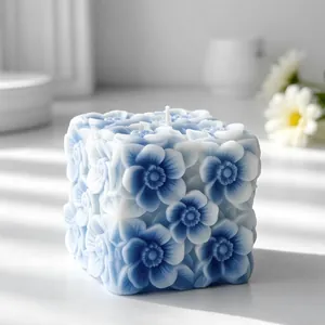 Vista dettagliata di una candela a cubo blu con intricati motivi floreali a rilievo