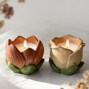 Detail of two lit lotus-shaped scented candles with warm glow and ceramic texture