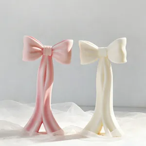 Vue détaillée de bougies en forme de nœud artisanales, texture mate et tons pastel doux